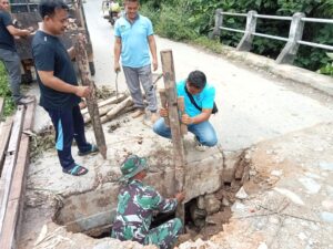 Babinsa Koramil 1204-12/Parindu Bersama Warga Gotong Royong Perbaiki Jembatan Rusak